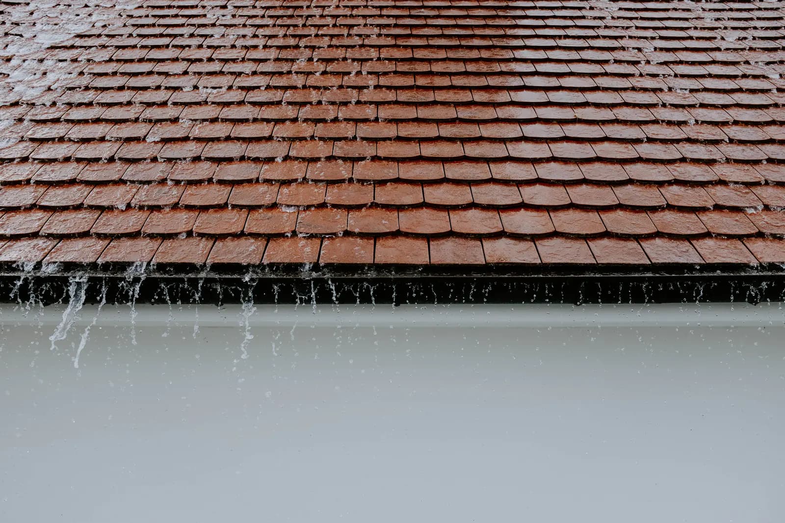 Regn falder på taget af et hus