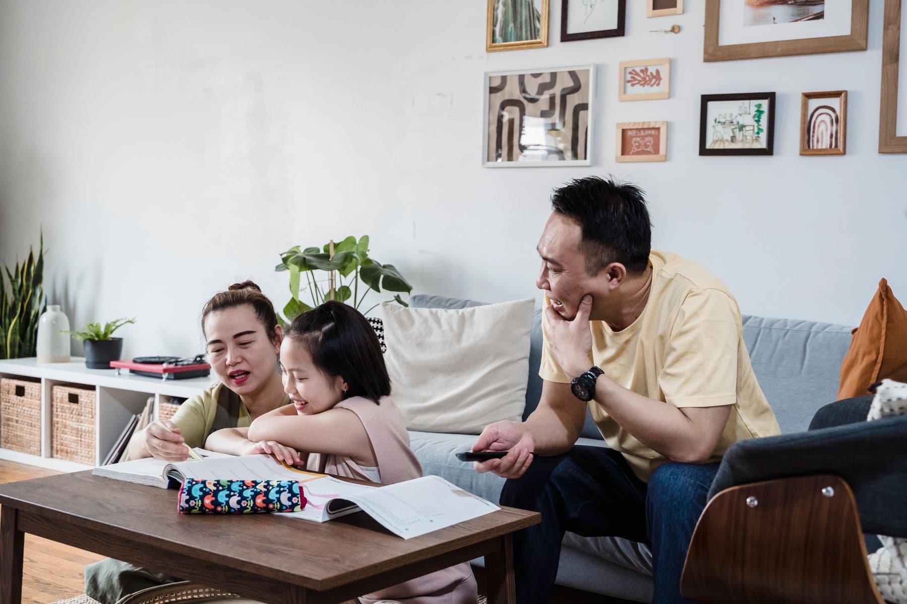 En familie er samlet om lektier og hverdagsliv i stuen