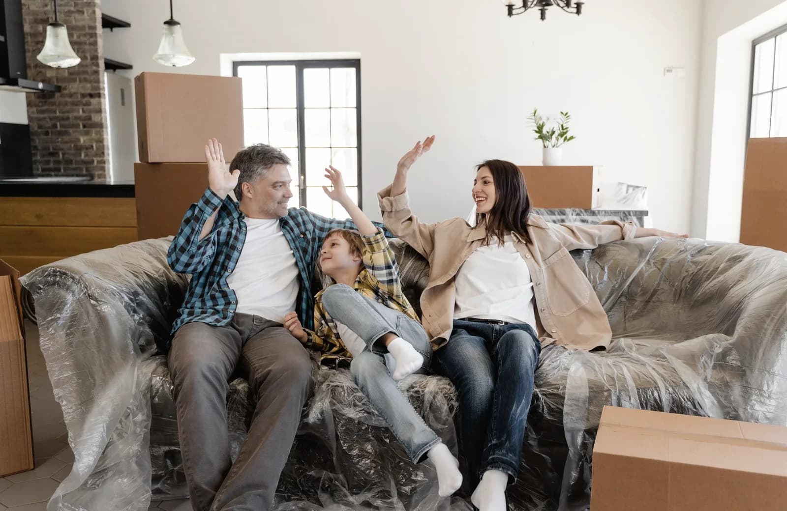 En familie sidder i stuen mellem flyttekasser