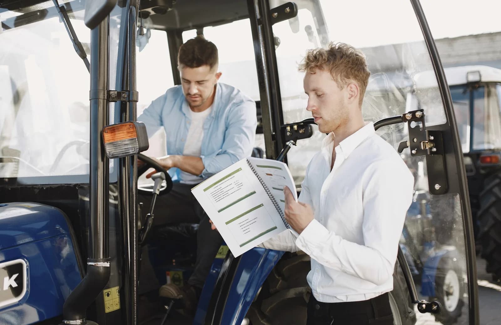 To personer gennemgår dokumenter ved en traktor