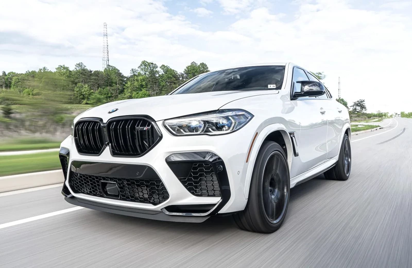 En hvid BMW kører på en landevej