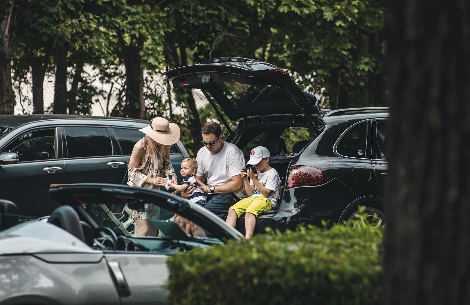 En familie gør bilen klar til ferie ved det åbne bagagerum