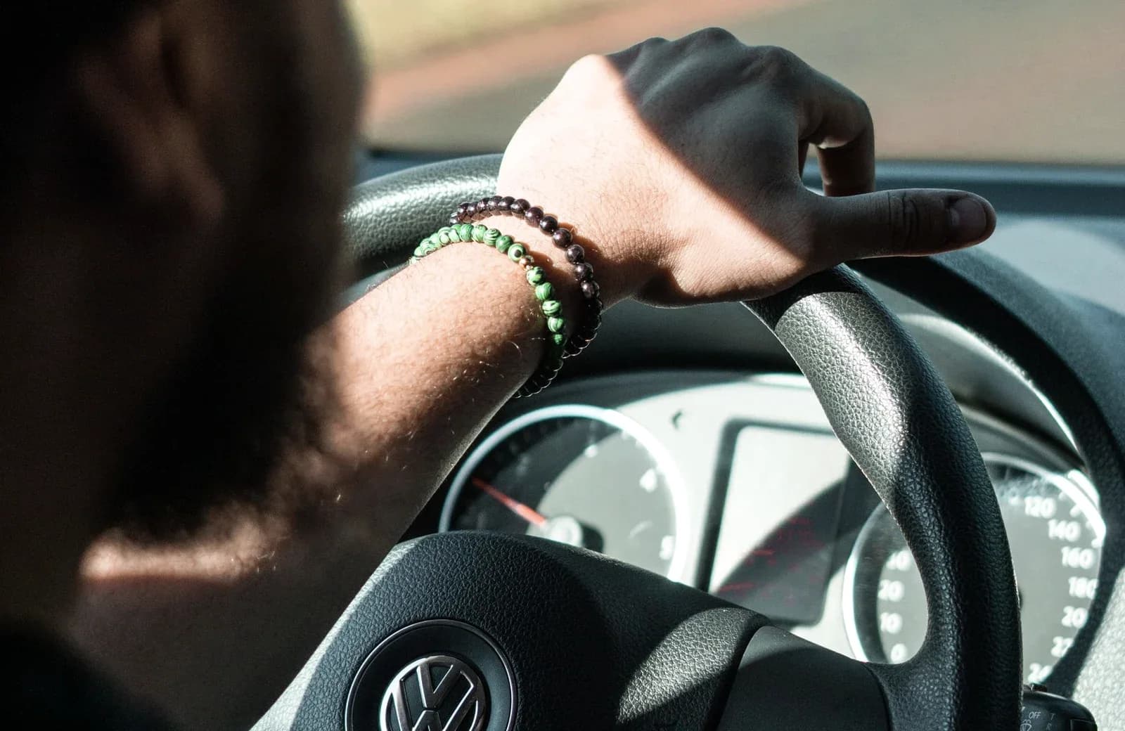 En bilist kører en VW på en solrig dag